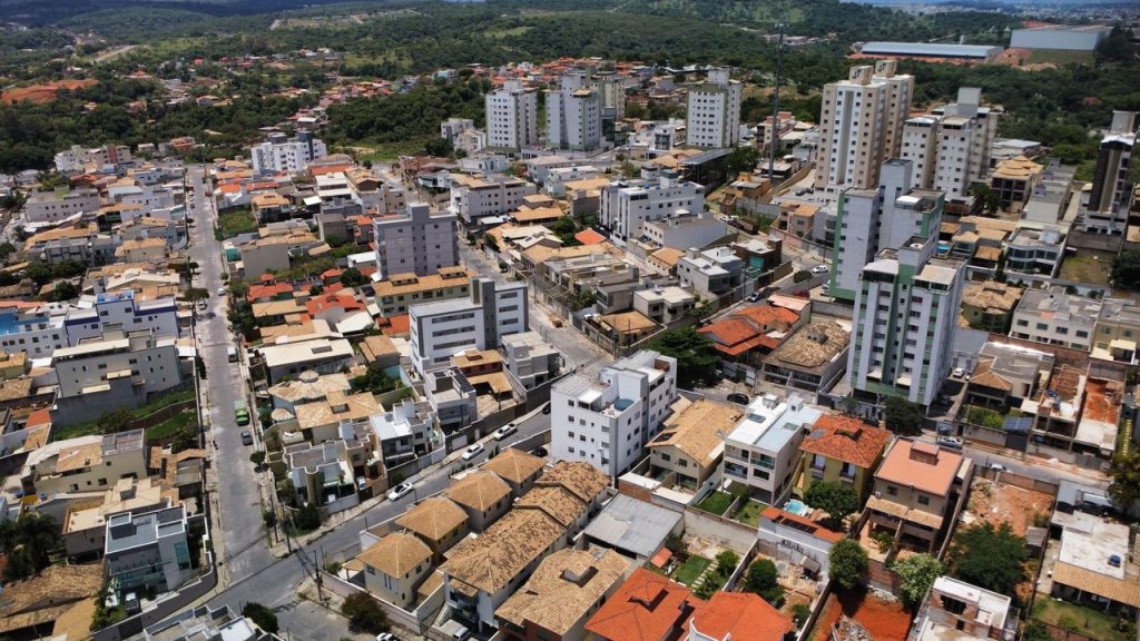 Vista aérea de um distrito residencial brasileiro, com ruas, casas e diferentes padrões de ocupação urbana.